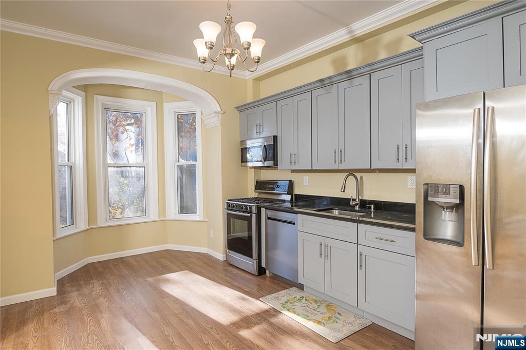 37 Riverside Avenue Little Ferry, NJ 07643 - Photo 11 of 34 a kitchen with stainless steel appliances granite countertop a stove top oven a refrigerator a sink and dishwasher with wooden floor
