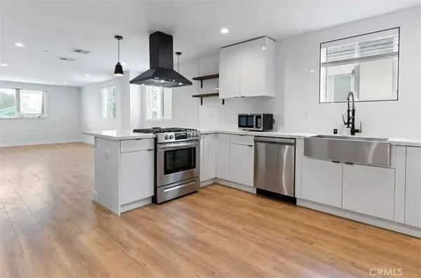 a kitchen with stainless steel appliances granite countertop a stove a sink and a refrigerator