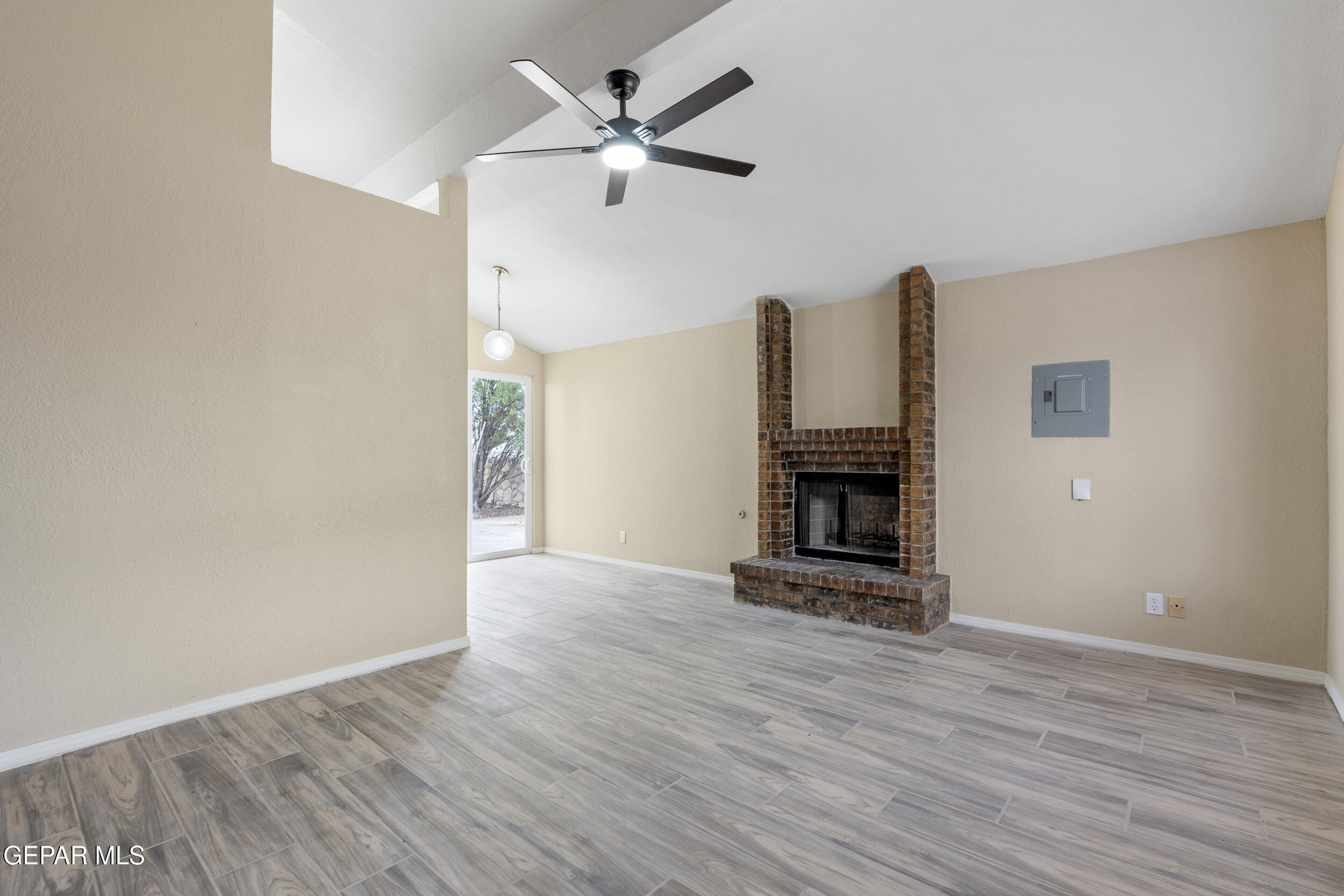 6708 Stone Court El Paso, TX 79924 - Photo 3 of 22 an empty room with wooden floor a fireplace a ceiling fan and wooden floor