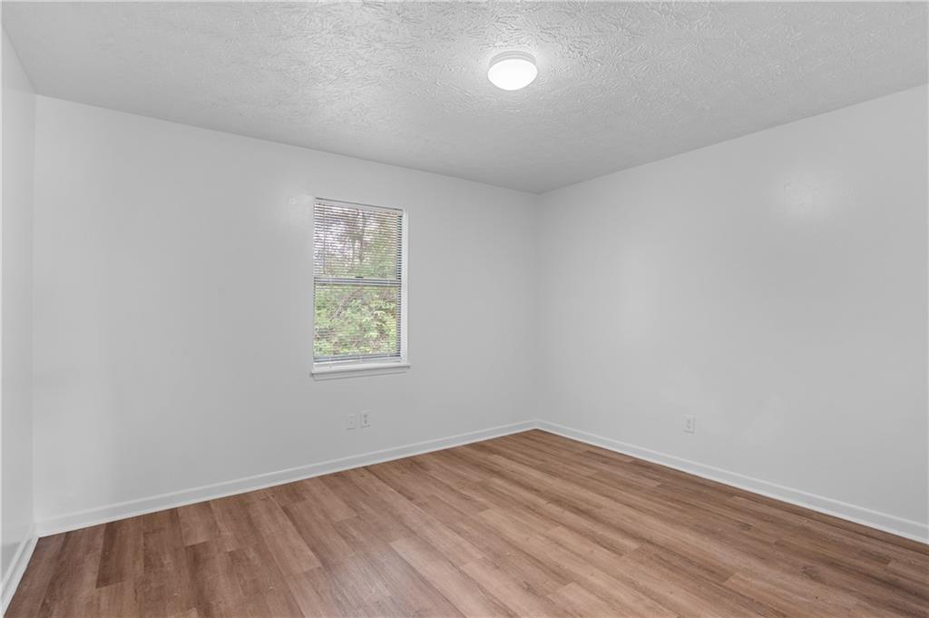 340 Tanglewood Drive, Unit A Monroe, GA 30656 - Photo 12 of 17 wooden floor in an empty room with a window