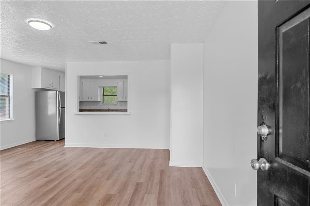 340 Tanglewood Drive, Unit A Monroe, GA 30656 - Photo 2 of 17 wooden floor in an empty room with a window