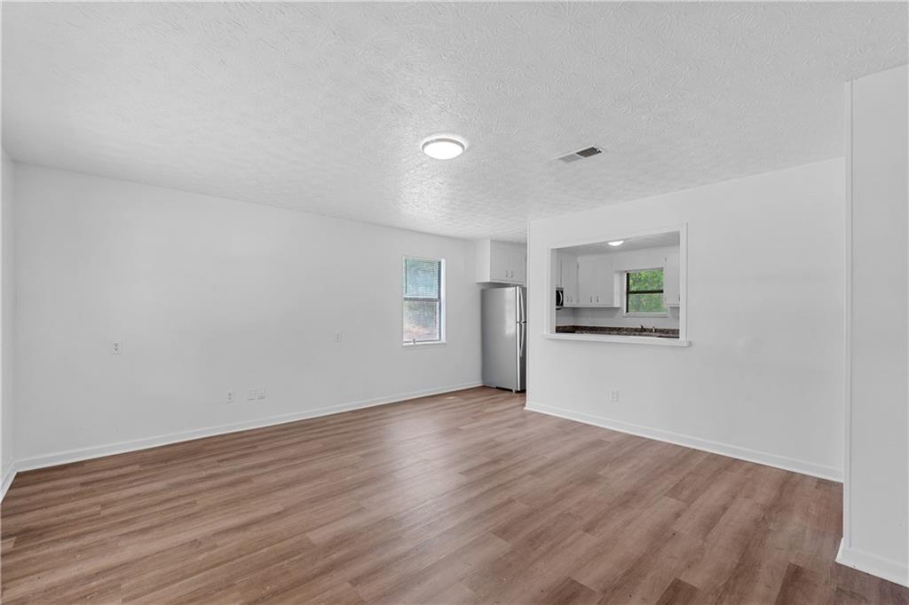 340 Tanglewood Drive, Unit A Monroe, GA 30656 - Photo 3 of 17 a view of an empty room with wooden floor and a window