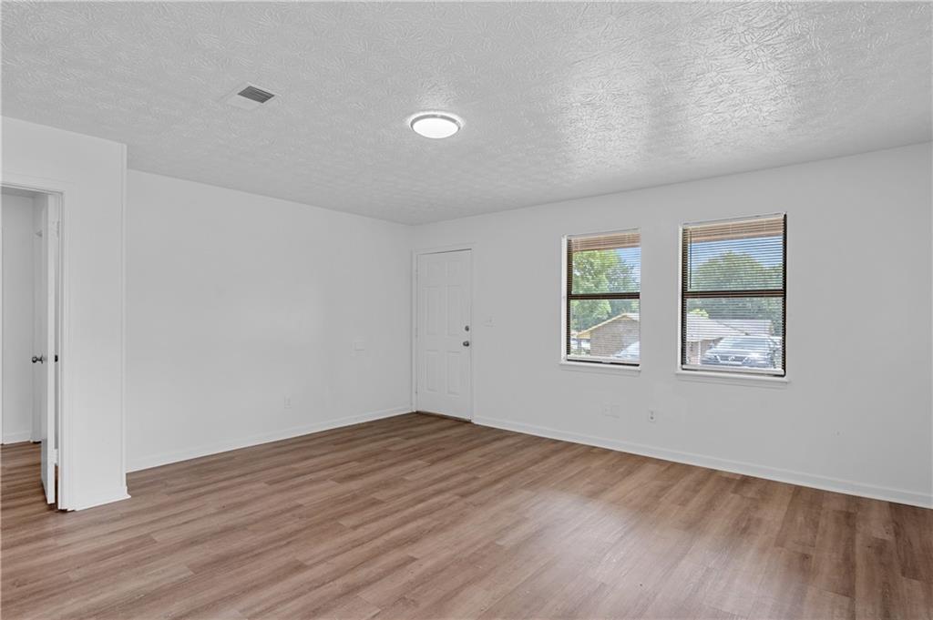 340 Tanglewood Drive, Unit A Monroe, GA 30656 - Photo 5 of 17 an empty room with wooden floor and windows
