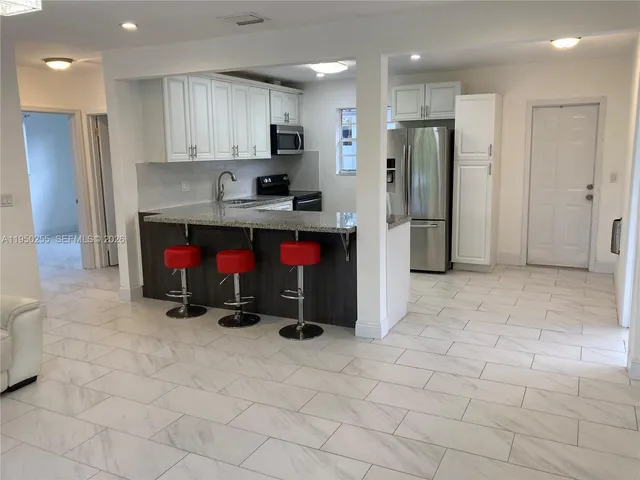 a kitchen with stainless steel appliances granite countertop a refrigerator and a stove