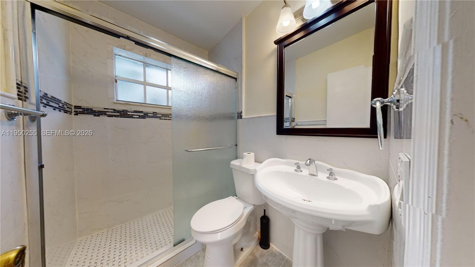 5720 Sheridan Street, Unit 1 Hollywood, FL 33021 - Photo 9 of 14 a bathroom with a sink toilet and mirror