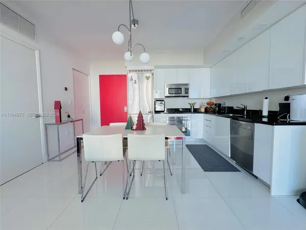 a kitchen with stainless steel appliances kitchen island granite countertop a sink a stove a refrigerator cabinets and chairs