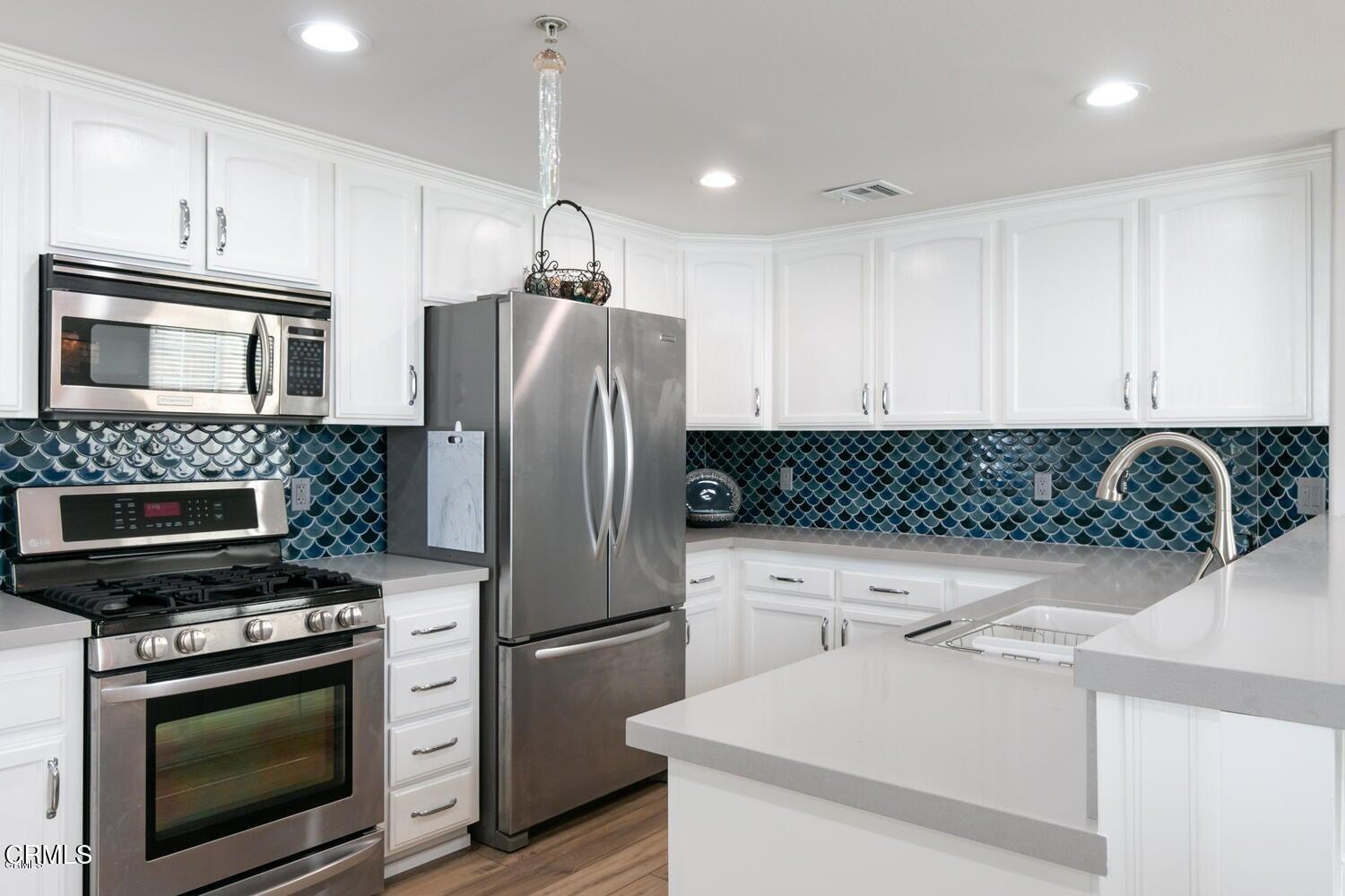 925 Dunes Street Oxnard, CA 93035 - Photo 3 of 27 a kitchen with a refrigerator sink and microwave