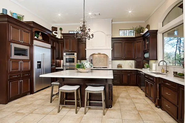 a kitchen with cabinets a sink stainless steel appliances and dining table