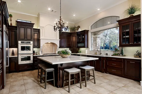 a kitchen with stainless steel appliances kitchen island granite countertop a table chairs sink and stove