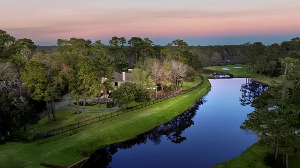 an aerial view of a house with a yard and lake view in back