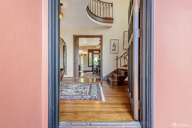 a living room with wooden floor and a rug