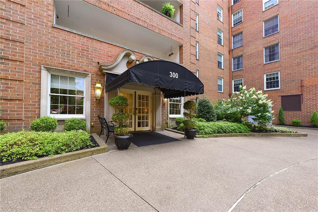 front view of a brick house with potted plants and a table and chairs