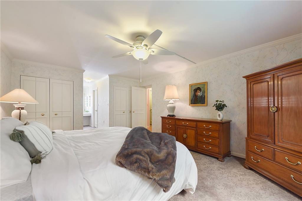 300 Fox Chapel Road, Unit 405 Pittsburgh, PA 15238 - Photo 22 of 30 a bedroom with a large bed and a chandelier