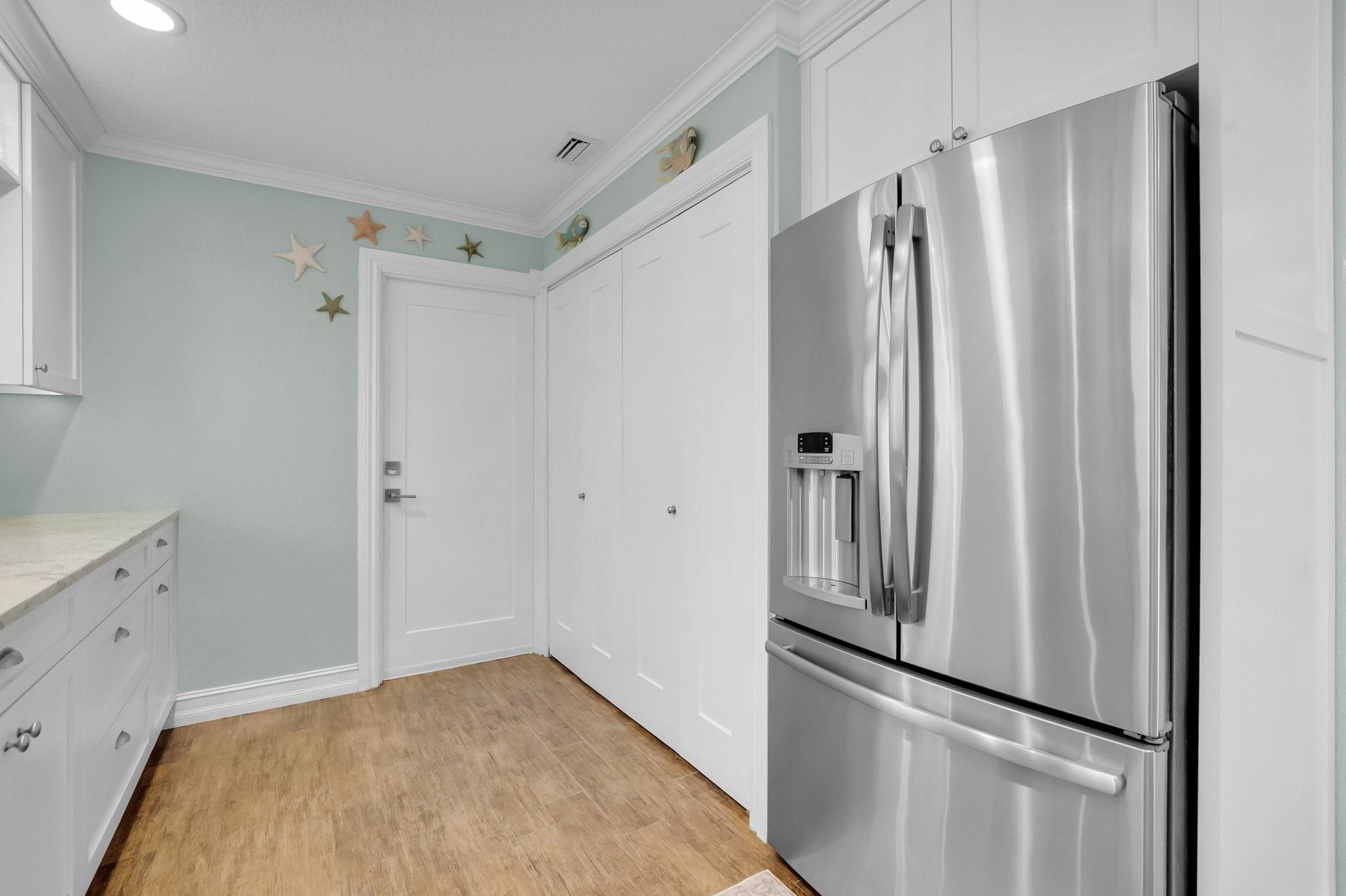 548 Northwest 55th Street Boca Raton, FL 33487 - Photo 17 of 33 a view of a refrigerator in kitchen and white cabinets