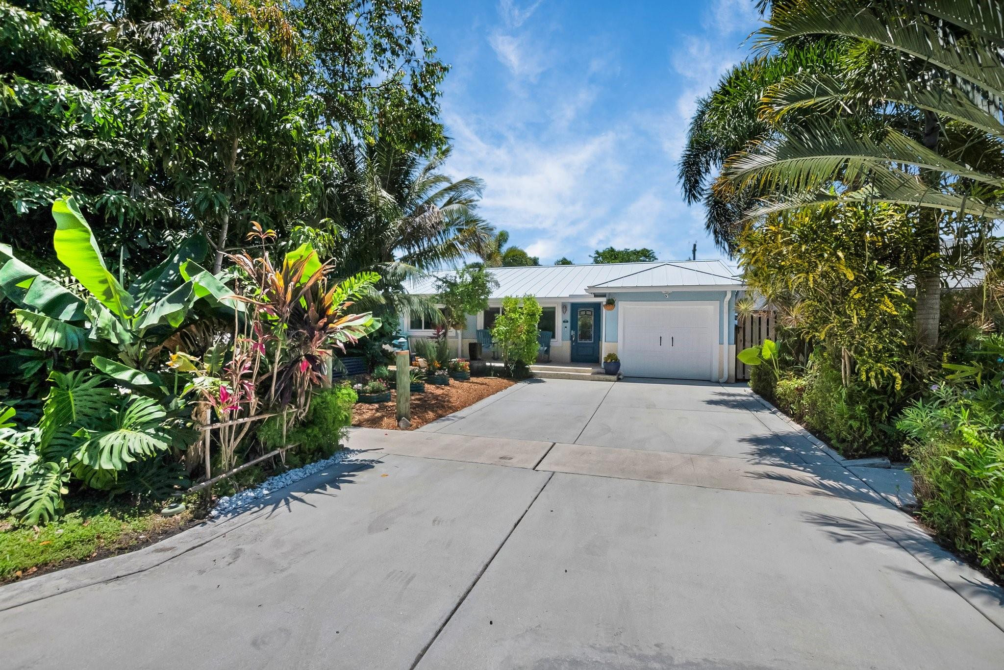 548 Northwest 55th Street Boca Raton, FL 33487 - Photo 2 of 33 a front view of a house with a yard and a garage