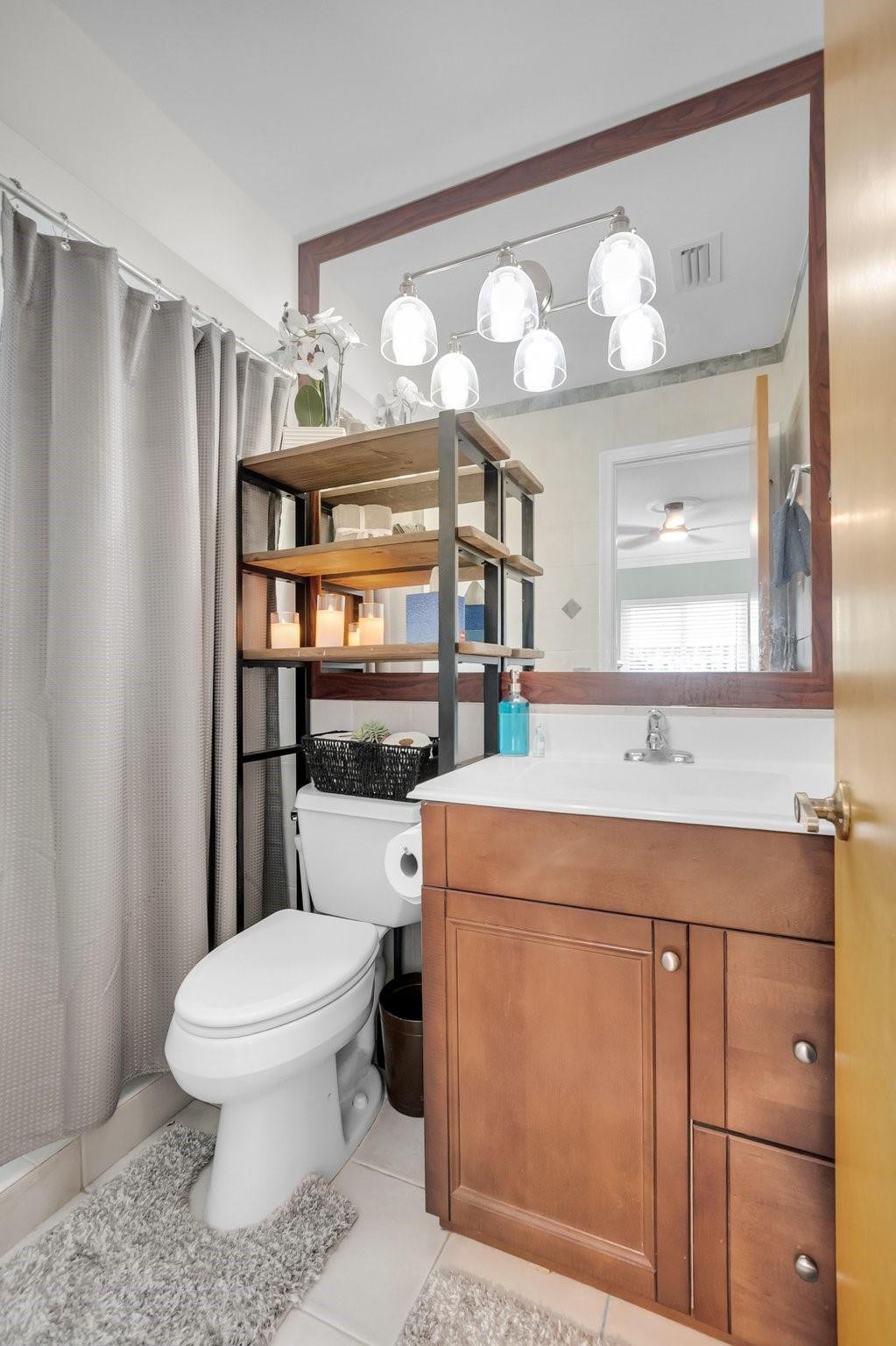 548 Northwest 55th Street Boca Raton, FL 33487 - Photo 22 of 33 a bathroom with a sink a toilet and a mirror