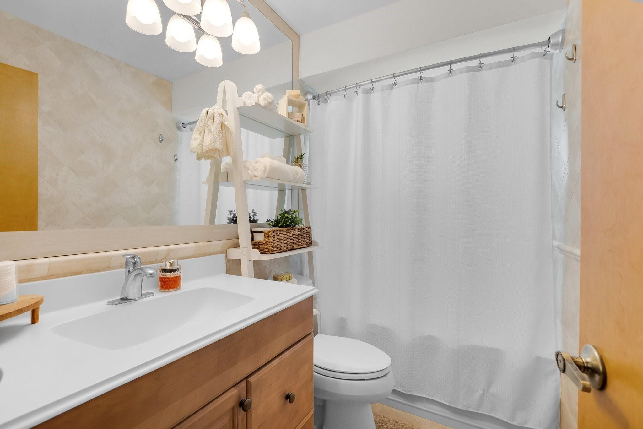 548 Northwest 55th Street Boca Raton, FL 33487 - Photo 25 of 33 a bathroom with a sink a toilet a mirror and shower curtain