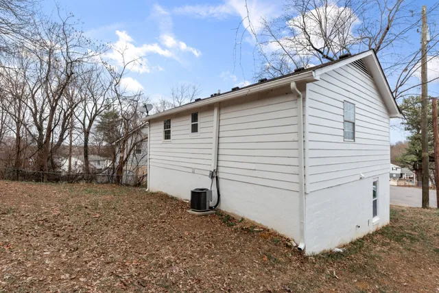 a view of a white house with a large tree