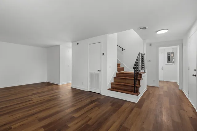 wooden floor in an empty room with a staircase