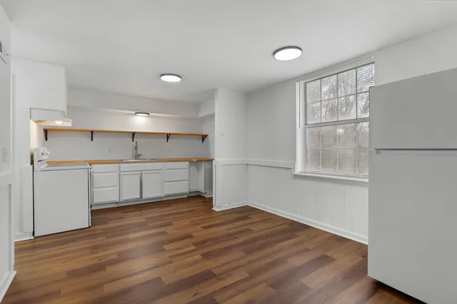 a view of a kitchen with wooden floor and windows