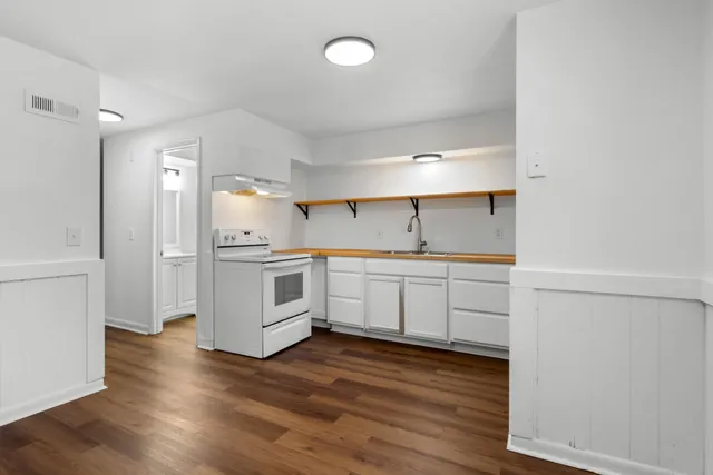 a kitchen with white cabinets and white appliances