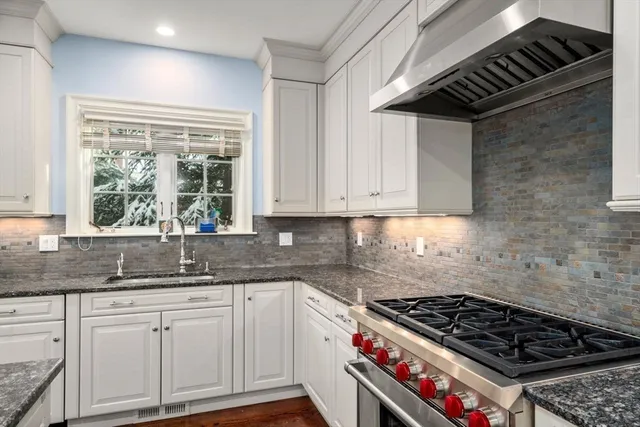 a kitchen with granite countertop a stove and a sink
