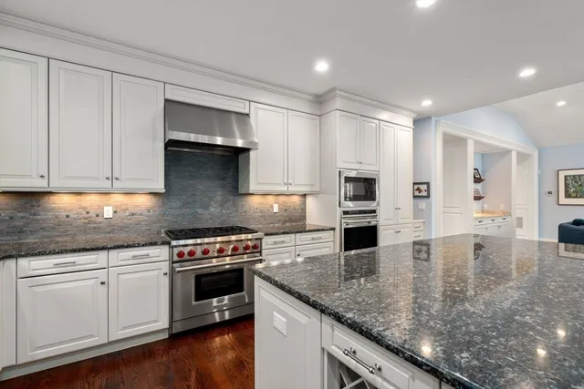 a kitchen with stainless steel appliances granite countertop a stove sink and cabinets