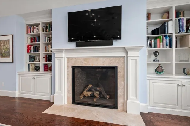 a living room with a fireplace and a book shelf