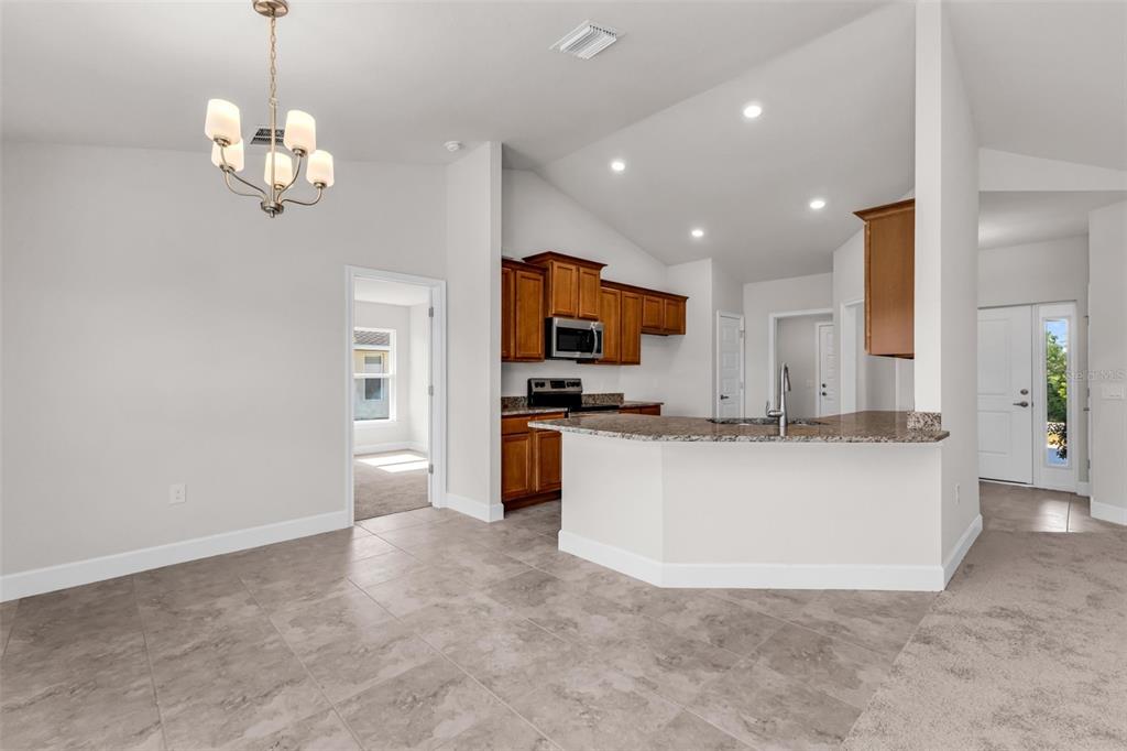 9500 Singer Circle Port Charlotte, FL 33981 - Photo 24 of 60 a living room with stainless steel appliances granite countertop couches a fireplace a flat screen tv and a kitchen island