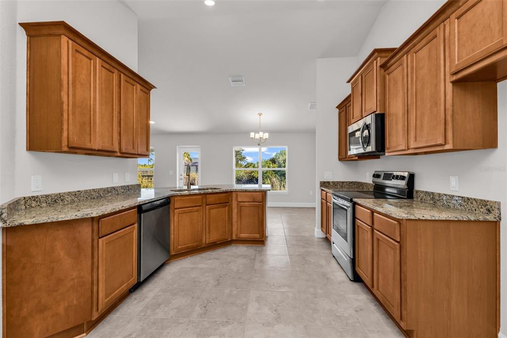 9500 Singer Circle Port Charlotte, FL 33981 - Photo 26 of 60 a kitchen with stainless steel appliances granite countertop a stove a sink dishwasher and a refrigerator