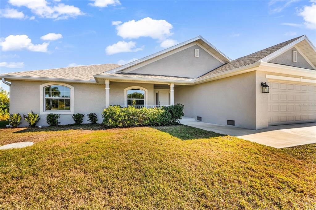 9500 Singer Circle Port Charlotte, FL 33981 - Photo 4 of 60 a front view of house with yard and trees in the background