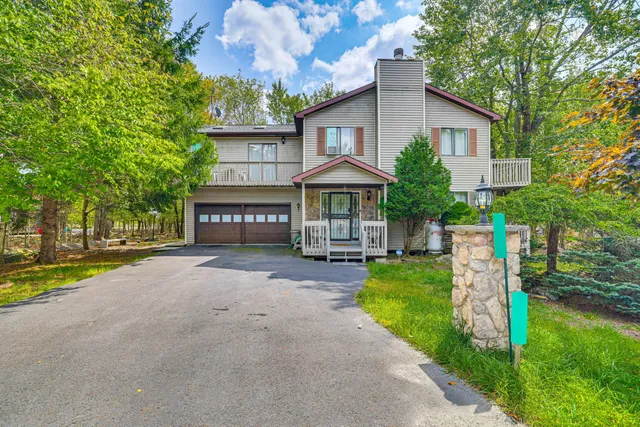 a front view of a house with yard and green space