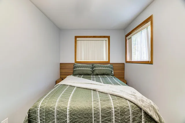 a bed sitting in a bedroom next to a window