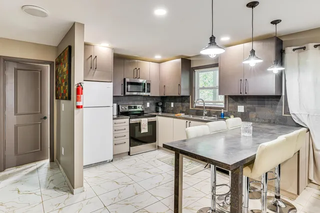 a kitchen with kitchen island a counter space a sink appliances and cabinets
