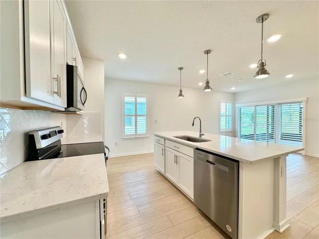 a kitchen with stainless steel appliances granite countertop a sink and stove