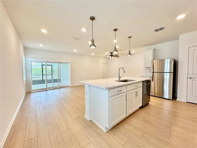 a kitchen with a sink cabinets and wooden floor