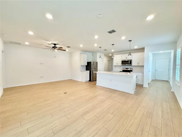 a view of kitchen with stainless steel appliances kitchen island a refrigerator sink and cabinets