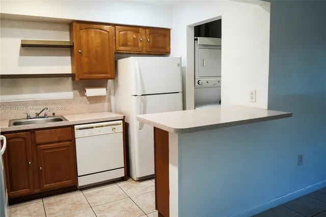 a kitchen with a refrigerator sink and cabinets