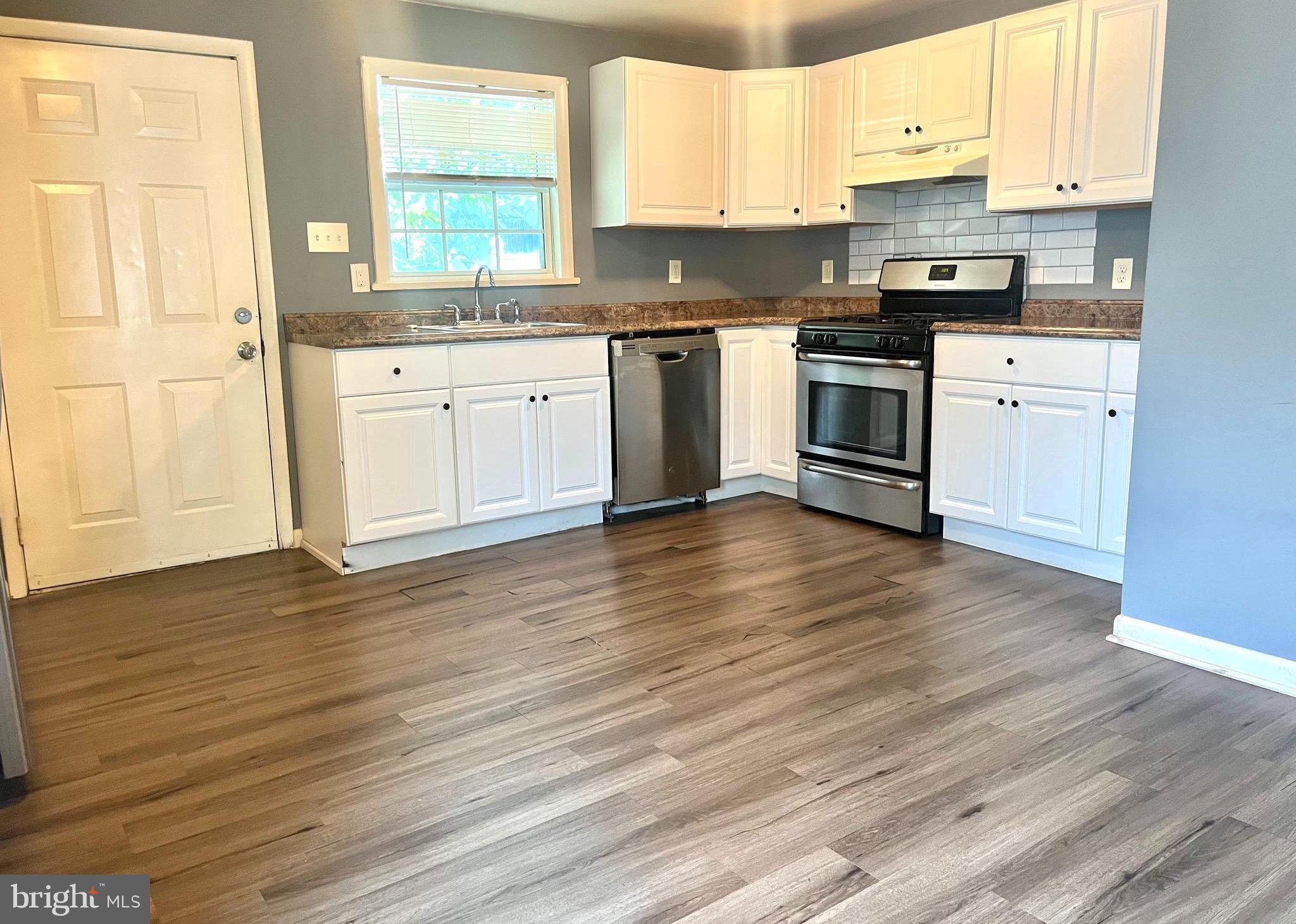 140 East Federal Street Burlington, NJ 08016 - Photo 6 of 18 a kitchen with stainless steel appliances granite countertop a stove a sink and white cabinets with wooden floor