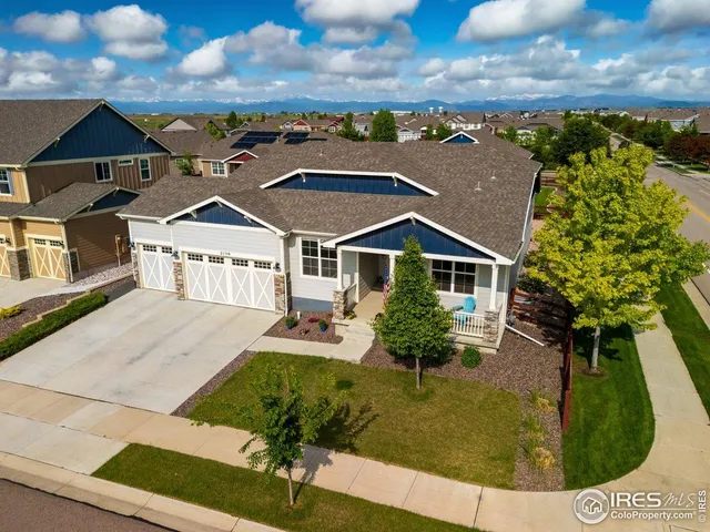 a view of a house with large windows and plants