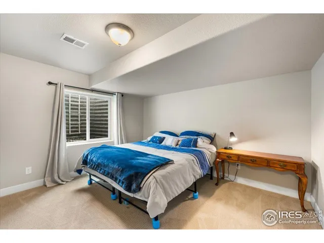 a bed sitting in a bedroom next to a window