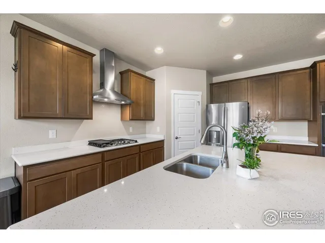 a kitchen with kitchen island granite countertop a sink stainless steel appliances and cabinets
