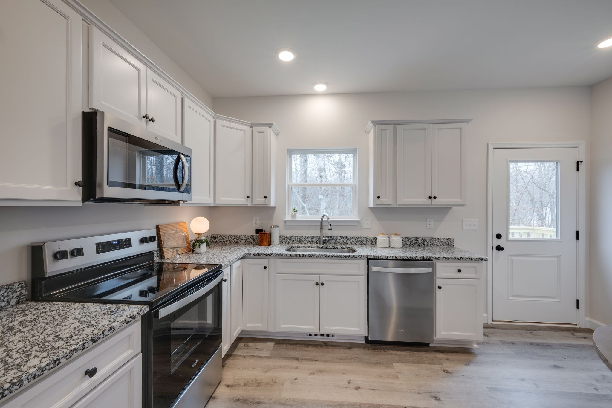 57 Truform Way Dickson, TN 37055 - Photo 11 of 29 a kitchen with stainless steel appliances granite countertop a stove a sink dishwasher and a microwave oven with wooden cabinets