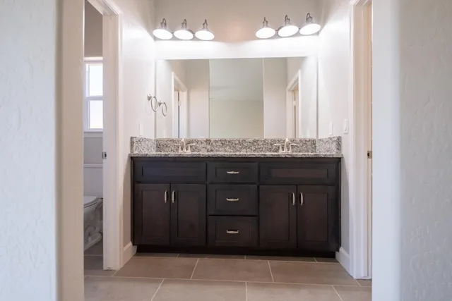 a bathroom with a sink vanity and a mirror