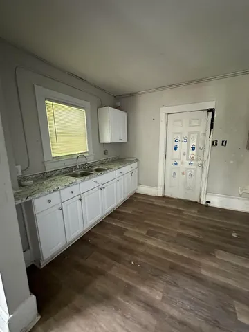 a spacious bathroom with a granite countertop sink and a mirror