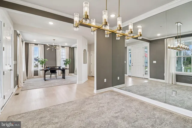 a kitchen with stainless steel appliances granite countertop a sink a stove a refrigerator cabinets and a dining table with wooden floor