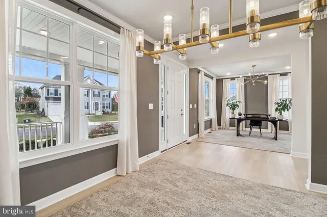 a dining room with stainless steel appliances kitchen island granite countertop a dining table chairs and white cabinets