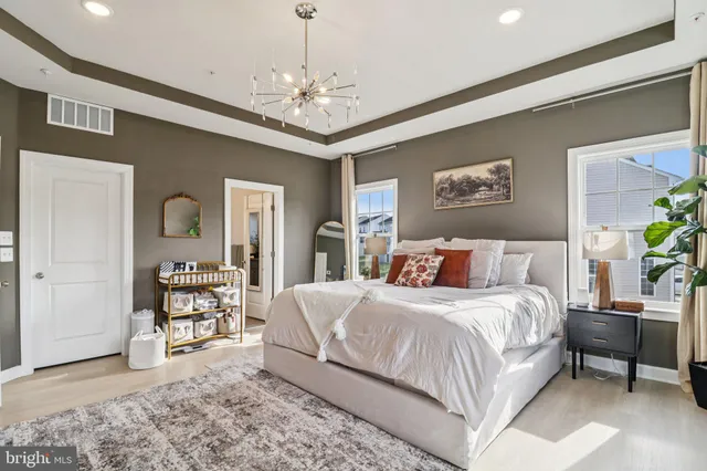 a bathroom with a granite countertop double vanity sink a mirror and a toilet