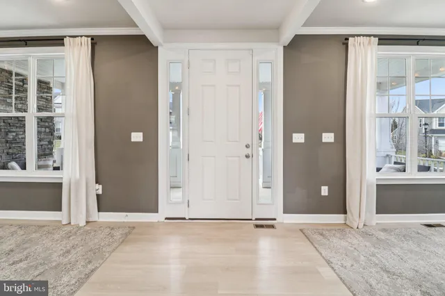 a living room with furniture kitchen view and a chandelier
