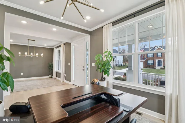 a kitchen with stainless steel appliances granite countertop a stove top oven a refrigerator a sink and a dining table with wooden floor